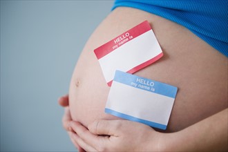 Name tags on belly of pregnant woman. 
Photo : Jamie Grill
