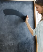 Woman erasing blackboard. 
Photo : Jamie Grill