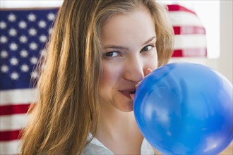 Woman blowing balloon. 
Photo : Jamie Grill