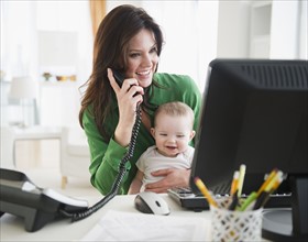 Mother with baby daughter (6-11 months) working in home office. 
Photo: Jamie Grill