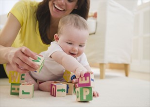 Mother and baby daughter (6-11 months) playing with blocks. 
Photo : Jamie Grill