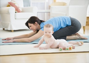 Mother with baby daughter (6-11 months) practicing yoga. 
Photo: Jamie Grill