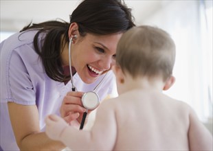 Female nurse with baby girl (6-11 months). 
Photo : Jamie Grill