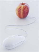 Close up of computer mouse and apple, studio shot. 
Photo: Daniel Grill