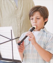 Boy (10-11 years) playing flute. 
Photo : Daniel Grill