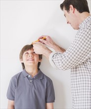 Father measuring son's (10-11 years) height. 
Photo : Daniel Grill