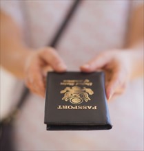 Close up of woman's hands holding passport. 
Photo : Daniel Grill