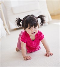 Baby girl (12-17 months) crawling on carpet. 
Photo : Daniel Grill