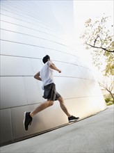 USA, California, Los Angeles, Young man running on city street.