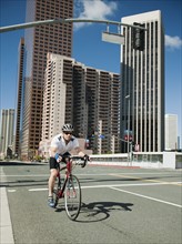 USA, California, Los Angeles, Young man road cycling on city street.
