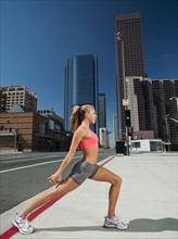 USA, California, Los Angeles, Young woman exercising on city street.