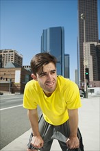 USA, California, Los Angeles, Young man resting after running on city street. 
Photo: Erik Isakson
