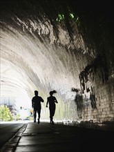 USA, California, Los Angeles, Man and woman running in tunnel. 
Photo: Erik Isakson