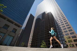 USA, California, Los Angeles, Young woman running in city.