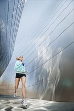 USA, California, Los Angeles, Young woman jogging in city.