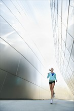 USA, California, Los Angeles, Young woman jogging in city.