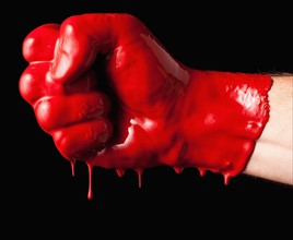 Human fist covered with red paint. 
Photo : Mike Kemp