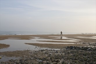 France, Pas-de-Calais, Escalles, Young woman on empty beach. 
Photo: Jan Scherders