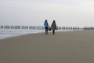 France, Pas-de-Calais, Escalles, Two women strolling on empty beach. 
Photo : Jan Scherders
