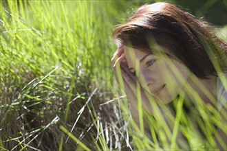 Young woman among green grass. 
Photo : Jan Scherders