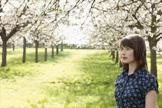 Belgium, Sint-Truiden, Portrait of young woman in spring orchard. 
Photo: Jan Scherders