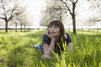 Belgium, Sint-Truiden, Portrait of young woman in spring orchard. 
Photo : Jan Scherders