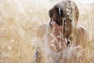 Young woman sitting on cornfield. 
Photo : Jan Scherders