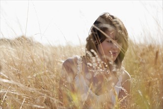 Young woman sitting on cornfield. 
Photo : Jan Scherders