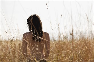 Young woman standing among cornfield. 
Photo : Jan Scherders