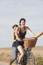 Young women on bikes on country road. 
Photo: Jan Scherders