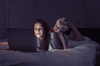 Mother with son using laptop in bed. 
Photo: King Lawrence