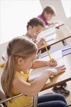 Schoolchildren focused on writing in classroom. 
Photo: Rob Lewine
