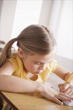 Schoolgirl focused on writing in classroom. 
Photo: Rob Lewine