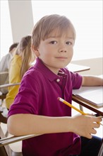 Schoolboy holding pencil in classroom. 
Photo: Rob Lewine