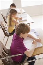 Schoolchildren focused on writing in classroom. 
Photo: Rob Lewine