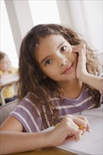 Portrait of schoolgirl holding pencil. 
Photo: Rob Lewine