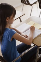 Schoolgirl focused on writing. 
Photo : Rob Lewine