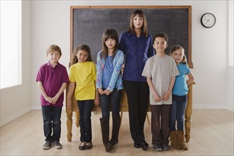 Teacher with group of pupils in front of blackboard. 
Photo: Rob Lewine