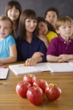 Teacher with group of pupils and apples on desk. 
Photo: Rob Lewine
