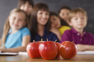 Teacher with group of pupils and apples on desk. 
Photo: Rob Lewine