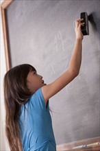 Schoolgirl writing on blackboard. 
Photo: Rob Lewine