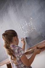 Schoolboy writing on blackboard. 
Photo: Rob Lewine