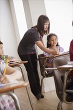 Teacher helping schoolchildren (6-7,8-9). 
Photo: Rob Lewine