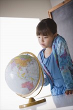Schoolgirl (8-9) with globe. 
Photo : Rob Lewine