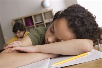 Girl (10-11) napping on desk with boy (10-11) in background. 
Photo : Rob Lewine