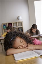 Girl (10-11) napping on desk with girl (12-13) and boy (10-11) in background. 
Photo : Rob Lewine