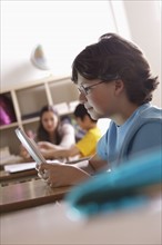 Portrait of schoolboy (10-11) with digital tablet. 
Photo : Rob Lewine