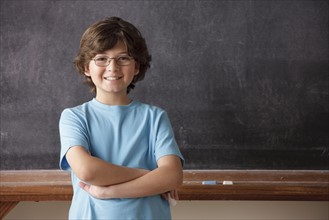 Portrait of schoolboy (10-11) in front of blackboard. 
Photo: Rob Lewine