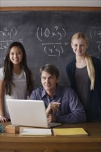 Portrait of maths teacher with two students (14-15). 
Photo : Rob Lewine