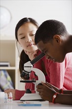 Teenage students (14-15) working with microscope. 
Photo : Rob Lewine